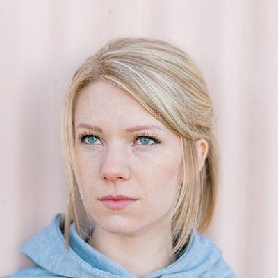 portrait-square-12 › Tarrant Elite Taekwondo Close-up portrait of a blonde woman with blue eyes, looking off to the left.